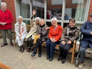 Madame ETHUIN entourée d'habitants sur un banc